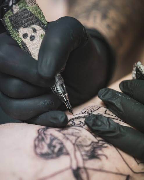 Tattoo artist working on a detailed tattoo in Bali